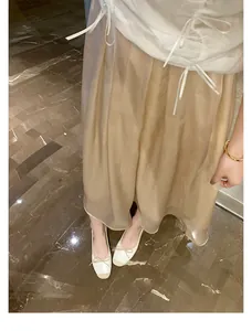Eleganti ballerine bicolore a punta quadrata con fiocco abbinate a una gonna midi