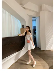 Dettaglio mini abito bianco con spalle scoperte stile francese e scarpe con fiocco bicolore