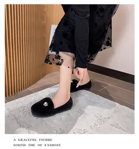 Close-up of black fuzzy flats featuring elegant pearl and rhinestone decorations