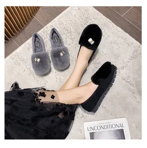 Close-up of plush loafers with pearl accents and thick non-slip rubber soles for winter