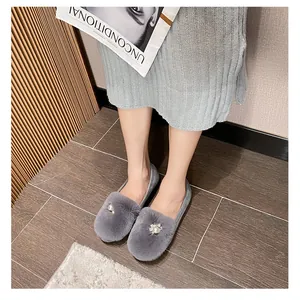Detail shot of grey faux fur flat shoes with pearl and rhinestone floral decoration