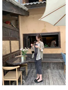 Ballerine nere da donna con fiocco abbinate a un elegante abito lungo grigio in un caffè