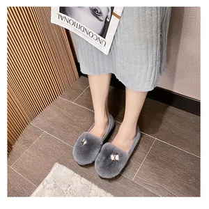 Detail of grey plush flat shoes with metal buckle decoration and soft faux fur material