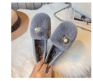 Detail view of grey faux fur flat shoes with pearl and rhinestone accents and warm lining
