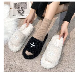 Detail of plush open-toe slippers with soft curly faux fur and cross embroidery