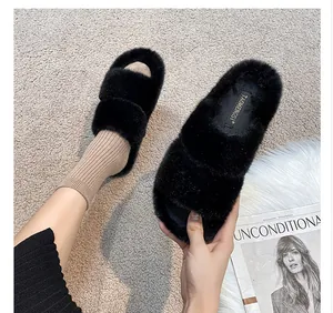Close-up of black fuzzy faux fur double-strap slides with plush texture and logo