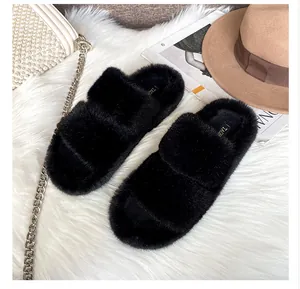 Close-up of black fuzzy slide sandals with double straps and plush faux fur material