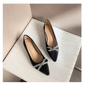 Draufsicht auf schwarze spitze Ballerinas mit funkelnder Strass-Schleife auf Texturfläche