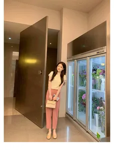 Scarpe basse beige con fiocco abbinate a maglia e pantaloni rosa in un ambiente lifestyle