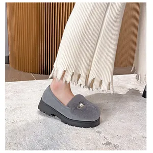 Detail eines grauen Wildleder-Loafers mit Kaninchenfell, Perle und Gummisohle