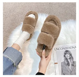 Close-up of brown plush open-toe slippers with soft faux fur texture and branded tag