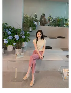 Donna elegante con ballerine con fiocco e top in maglia beige in uno stile urbano