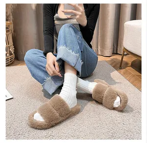 Detailed close-up of brown plush faux fur slippers with platform soles on a model