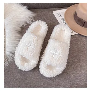 Flat fluffy slippers with star embroidery in cream white plush on a cozy gray background
