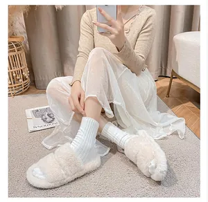 Detailed view of beige plush faux fur slide sandals with thick soles and soft texture