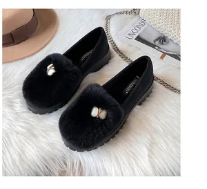 Nahaufnahme der schwarzen Wildleder-Loafer mit Pelzbesatz und weißer Steinschnalle