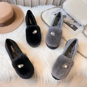 Schicke Plüsch-Loafer mit Perlenschnalle auf weißem Kunstpelz-Hintergrund