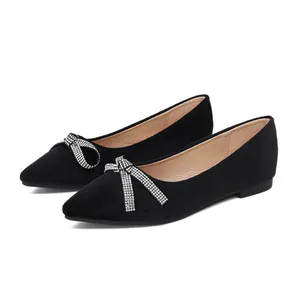 Elegante schwarze spitze Ballerinas mit funkelnder Kristall-Schleife auf weißem Hintergrund