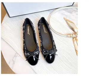 Top view of tweed ballerina flats with black patent leather toe and bow detail
