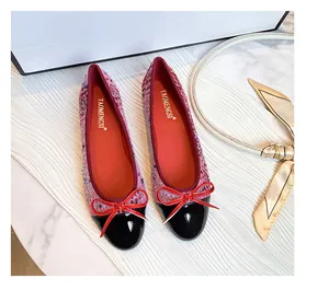 Detailed top view of tweed ballet flats with black patent toe and red bow accent