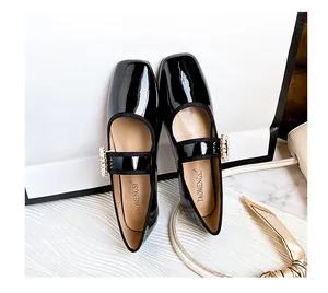 Dettaglio di scarpe Mary Jane in pelle verniciata a punta quadrata con fibbia di perle e strass