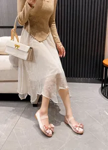 Ballerines en satin rose avec nœud et brides élastiques portées dans un décor moderne