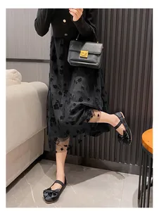 Look chic avec robe en tulle fleurie, ballerines à nœud et sac à main élégant noir