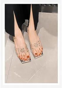 Detailaufnahme der eckigen transparenten Sandalen mit glitzernden Strasssteinen und Silber