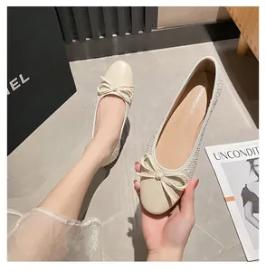 Detailansicht der beigen Ballerinas mit Tweed-Struktur und Leder-Schleifen-Akzenten