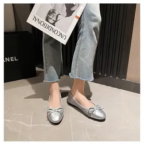 Nahaufnahme von silbernen Ballerinas mit Schleifendetail und schimmernder Paillettenstruktur