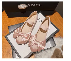Gros plan de ballerines en satin rose avec un grand nœud sur un emballage élégant