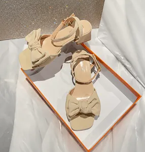 Detalle de sandalias beige con punta cuadrada, lazo suave y correa en el tobillo