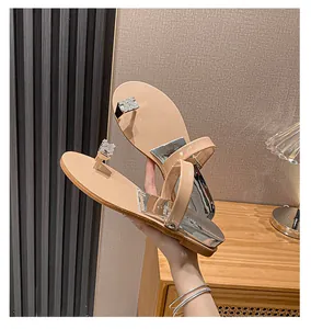 Detailed view of nude flip-flop sandals with rhinestone H buckle and silver accents
