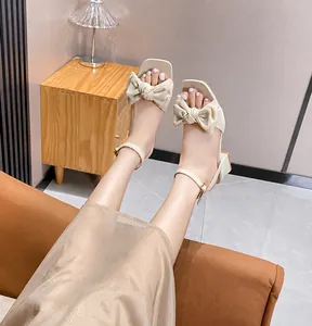 Primer plano de sandalias beige de punta cuadrada con lazo y correa al tobillo