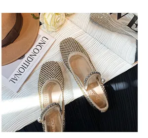 Close-up of mesh flat Mary Jane shoes with gold rhinestones and pearl detail
