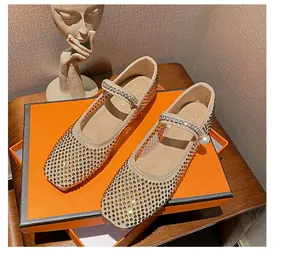 Close-up of square-toe mesh Mary Janes with full rhinestones and pearl on an orange box