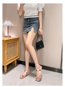 Silver toe-ring flat sandals with rhinestone gem decoration worn with casual denim skirt