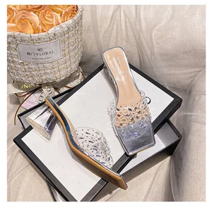 Detail von Sandalen mit quadratischer Spitze und Strassblume auf transparentem PVC