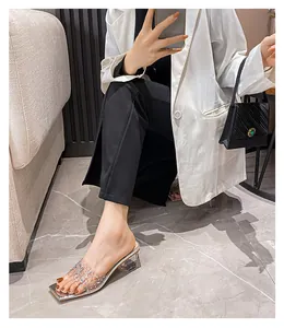 Details der eckigen Sandale mit transparentem PVC-Riemen und glänzenden Kristallen
