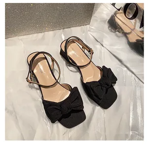 Elegantes sandalias negras de punta cuadrada con lazo grande y correa en el tobillo