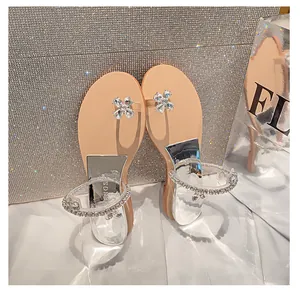 Makro-Detail der Keil-Flip-Flop mit Kristall-Blumenschnalle und Strass-Klarsichtriemen