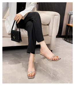 Nahaufnahme der transparenten PVC-Sandalen mit funkelndem Strassbesatz und eckiger Zehenpartie