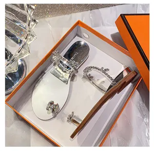 Detailansicht der Strass-Blumenschnalle und transparenten Riemen an flachen Sandalen