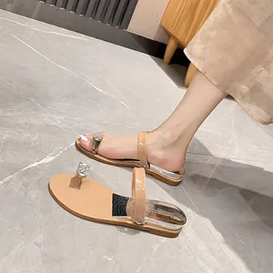 Beige flat thong sandals with square rhinestone toe rings and silver metallic heel detail