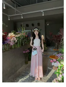 Elegantes Sommer-Urlaubsoutfit mit cremefarbenem Strick-Top und fließendem rosa Maxirock