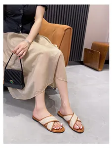 Detailaufnahme der geflochtenen Kreuzriemen-Sandalen mit Lederbesatz an einem Model