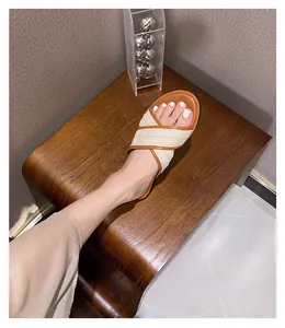 Damen flache Sandalen mit beige geflochtenen Kreuzgurten und braunem Rand am Fuß