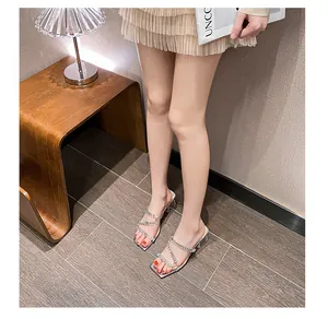 Detailopname van zilveren sandalen met vierkante neus, sprankelende strass en een heldere hak