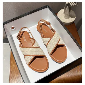 Flache geflochtene Sandalen mit Überkreuzriemen in Braun und Creme in einem Schuhkarton