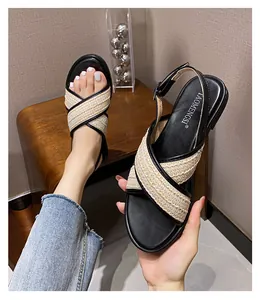 Detailansicht der gewebten Kreuzriemen-Sandalen mit beigefarbener Textur und schwarzer Paspel